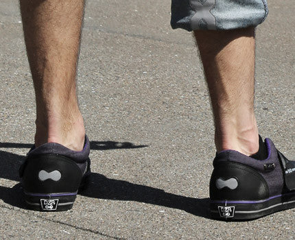 Model wearing purple clipless mtb shoes walking with bike, showcasing casual cycling shoes comfort